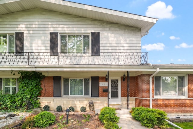 7013 W Greenleaf St, Niles, IL 60714 - view of front of property featuring a balcony, brick siding, a porch, and stone siding
