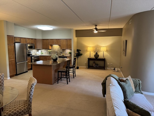 1479 N Milwaukee Ave Unit 312, Libertyville, IL 60048 - kitchen with appliances with stainless steel finishes, open floor plan, light colored carpet, a breakfast bar area, and ceiling fan