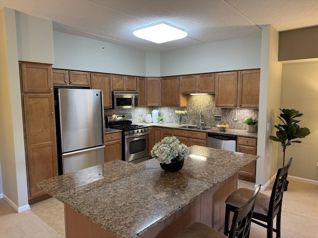 1479 N Milwaukee Ave Unit 312, Libertyville, IL 60048 - kitchen with stainless steel appliances, a breakfast bar area, decorative backsplash, dark stone counters, and a textured ceiling