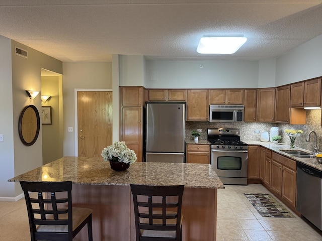 1479 N Milwaukee Ave Unit 312, Libertyville, IL 60048 - kitchen with appliances with stainless steel finishes, stone counters, decorative backsplash, a center island, and a breakfast bar area
