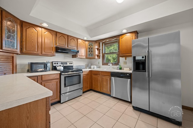 1340 Ironwood Ct, Aurora, IL 60506 - kitchen featuring appliances with stainless steel finishes, light countertops, brown cabinets, recessed lighting, and light tile patterned floors