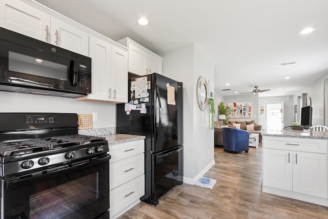 1523 Eadens Pl Unit 1523, Dixon, IL 61021 - kitchen featuring black appliances, white cabinetry, light wood-type flooring, open floor plan, and light stone counters