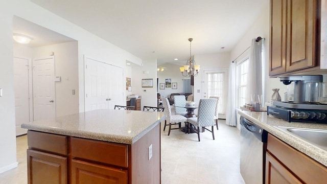 514 Luria Ln, Champaign, IL 61822 - kitchen with stainless steel dishwasher, a kitchen island, a chandelier, light stone countertops, and brown cabinets