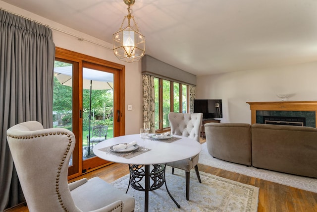 856 Fieldcrest Dr, Bolingbrook, IL 60490 - dining room with a chandelier, wood finished floors, and a tiled fireplace