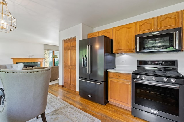 856 Fieldcrest Dr, Bolingbrook, IL 60490 - kitchen featuring gas stove, high quality fridge, light wood-style floors, a chandelier, and light countertops