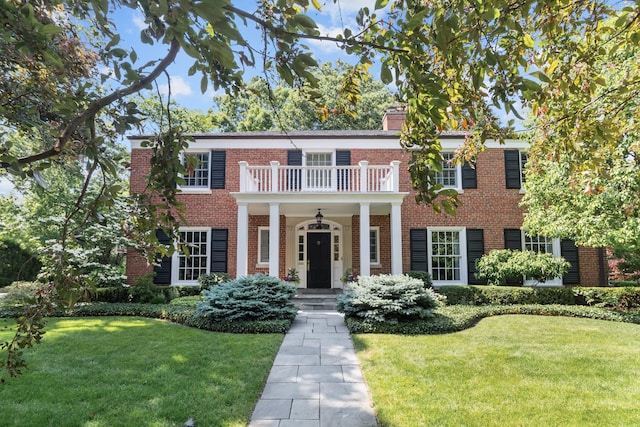 545 Sheridan Rd, Winnetka, IL 60093 - georgian-style home featuring a balcony, a front yard, brick siding, and a chimney