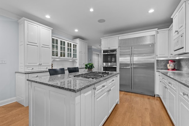 545 Sheridan Rd, Winnetka, IL 60093 - kitchen with stainless steel appliances, white cabinetry, a center island, light wood-style floors, and recessed lighting