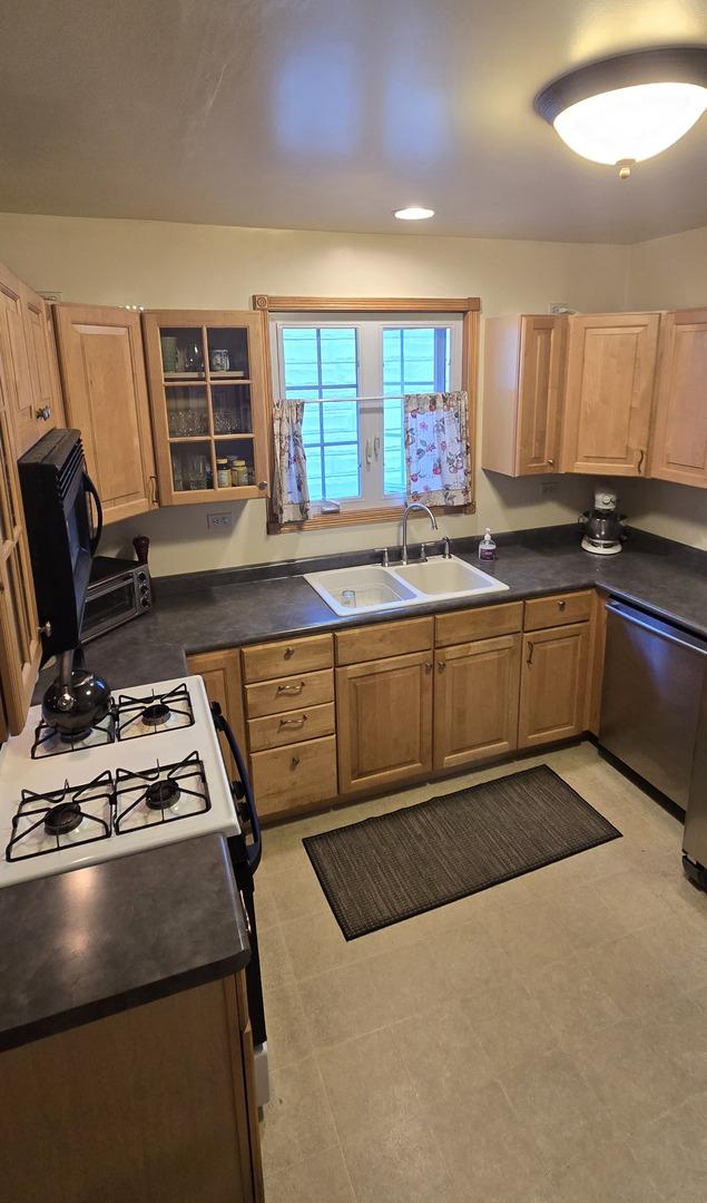 6119 W School St, Chicago, IL 60634 - kitchen with gas stove, stainless steel dishwasher, dark countertops, light brown cabinetry, and recessed lighting