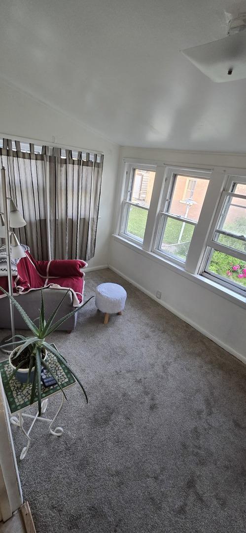 6119 W School St, Chicago, IL 60634 - carpeted living area with baseboards