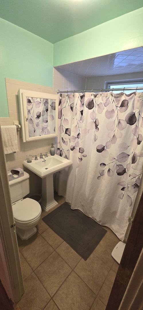 6119 W School St, Chicago, IL 60634 - full bath featuring tile patterned floors and a shower with shower curtain
