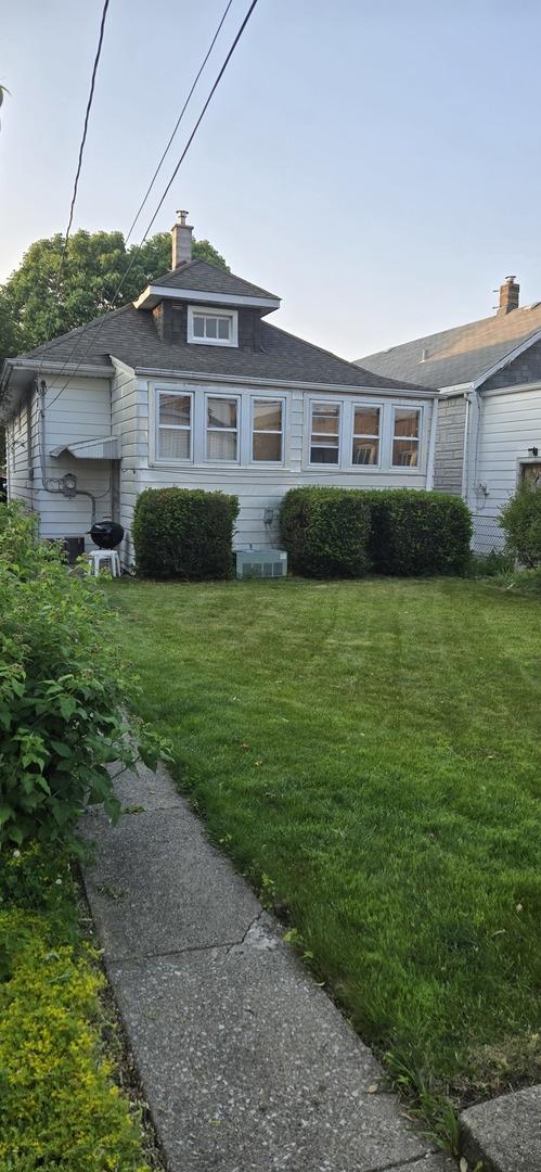 6119 W School St, Chicago, IL 60634 - view of front facade featuring a front lawn and a chimney