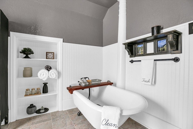 201 W Yates, Newman, IL 61942 - bathroom featuring a soaking tub, a wainscoted wall, and stone finish floors