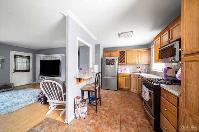 413 Glen Ave, Romeoville, IL 60446 - kitchen with appliances with stainless steel finishes, healthy amount of natural light, backsplash, and brown cabinets