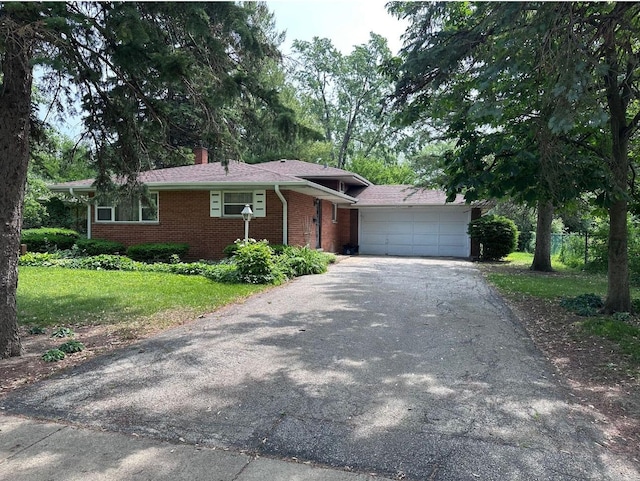 301 N Stevenson Ln, Mount Prospect, IL 60056 - view of front of house with asphalt driveway, brick siding, an attached garage, a front yard, and a chimney