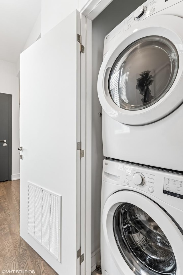 2138 N Sawyer Ave Unit 2, Chicago, IL 60647 - laundry room featuring stacked washer and clothes dryer and wood finished floors