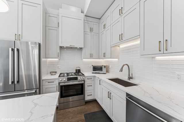 2138 N Sawyer Ave Unit 2, Chicago, IL 60647 - kitchen featuring appliances with stainless steel finishes, decorative backsplash, dark wood-style flooring, light stone countertops, and white cabinetry