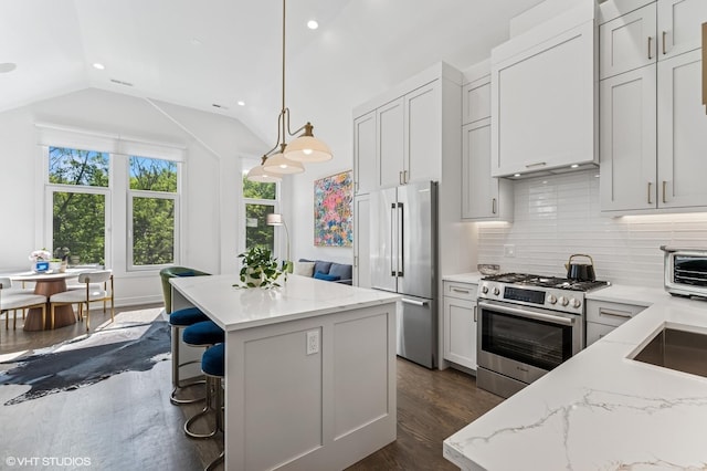 2138 N Sawyer Ave Unit 2, Chicago, IL 60647 - kitchen featuring appliances with stainless steel finishes, vaulted ceiling, a center island, backsplash, and dark wood-style floors
