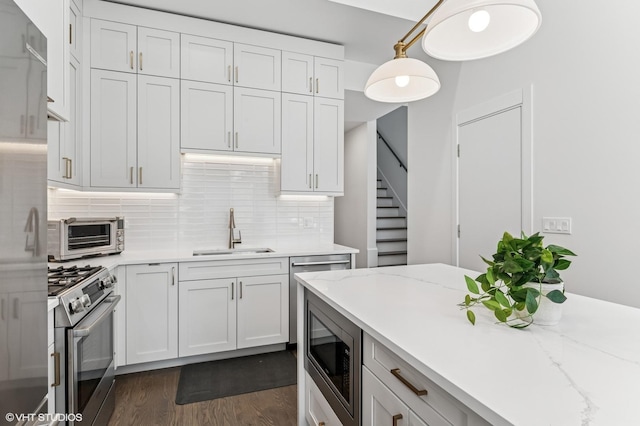 2138 N Sawyer Ave Unit 2, Chicago, IL 60647 - kitchen with stainless steel appliances, dark wood finished floors, backsplash, and white cabinetry