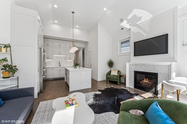 2138 N Sawyer Ave Unit 2, Chicago, IL 60647 - living area with dark wood-type flooring, lofted ceiling, a glass covered fireplace, and recessed lighting