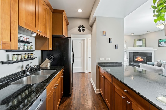2656 N Hamlin Ave Unit 1W, Chicago, IL 60647 - kitchen featuring dark wood-type flooring, brown cabinetry, a fireplace, and dark stone countertops