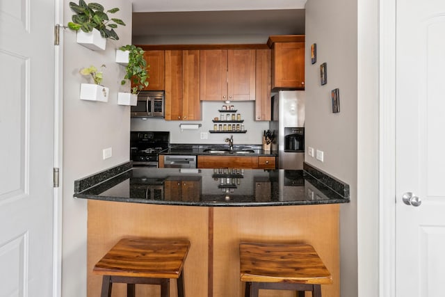 2656 N Hamlin Ave Unit 1W, Chicago, IL 60647 - kitchen with appliances with stainless steel finishes, a peninsula, dark stone countertops, and brown cabinets