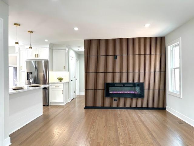 7646 W Myrtle Ave, Chicago, IL 60631 - unfurnished living room with light wood-style flooring, a glass covered fireplace, and recessed lighting