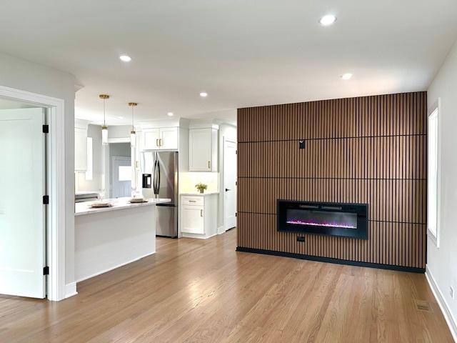7646 W Myrtle Ave, Chicago, IL 60631 - unfurnished living room featuring wood finished floors, recessed lighting, and a glass covered fireplace