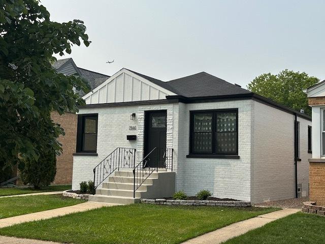 7646 W Myrtle Ave, Chicago, IL 60631 - view of front of home with brick siding, a front yard, and board and batten siding