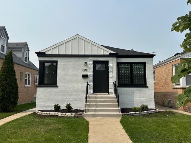 7646 W Myrtle Ave, Chicago, IL 60631 - view of front of home featuring brick siding, a front yard, and board and batten siding