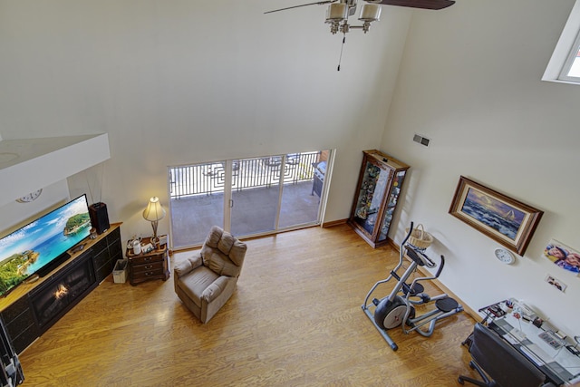 7050 183rd St Unit 409, Tinley Park, IL 60477 - living room with a towering ceiling, wood finished floors, ceiling fan, and a tile fireplace