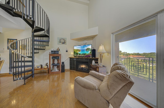 7050 183rd St Unit 409, Tinley Park, IL 60477 - living area featuring a high ceiling, light wood-style flooring, a tile fireplace, and stairs