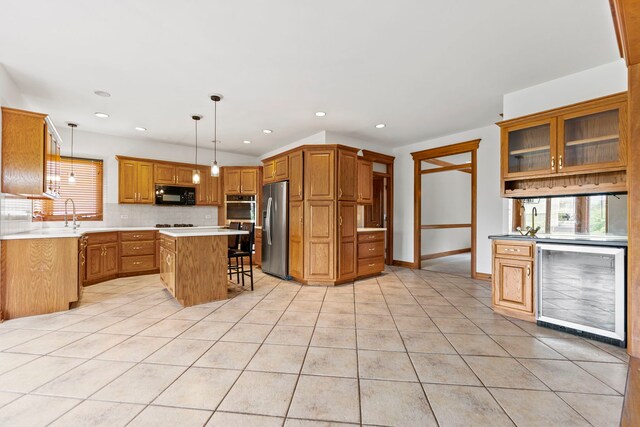 552 Waters Edge Dr, South Elgin, IL 60177 - kitchen with black microwave, stainless steel fridge, beverage cooler, decorative backsplash, and a center island