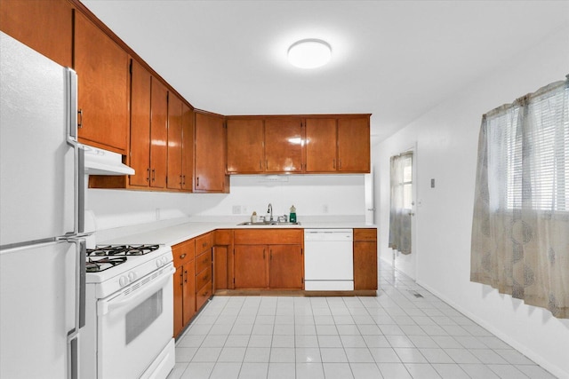 2407 W William St, Champaign, IL 61821 - kitchen featuring white appliances, light countertops, under cabinet range hood, light tile patterned floors, and brown cabinets