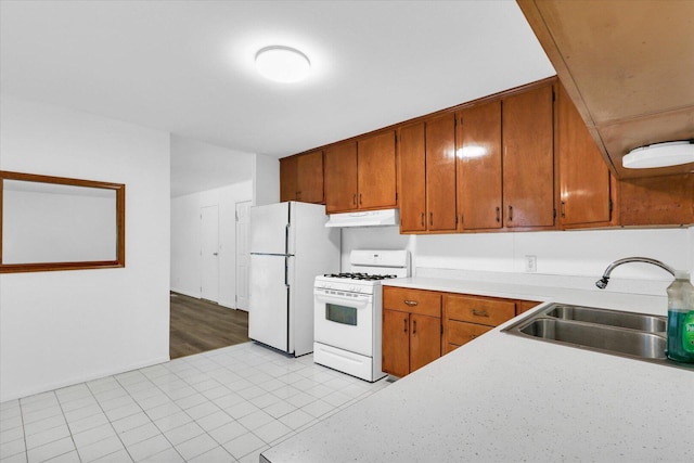 2407 W William St, Champaign, IL 61821 - kitchen featuring white appliances, under cabinet range hood, light countertops, and brown cabinets