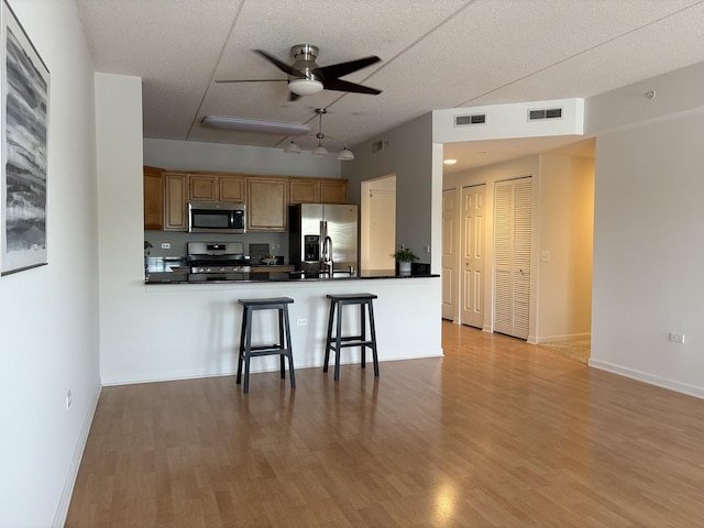 200 N Addison Ave Unit 505, Elmhurst, IL 60126 - kitchen with appliances with stainless steel finishes, a ceiling fan, dark countertops, light wood-type flooring, and a textured ceiling