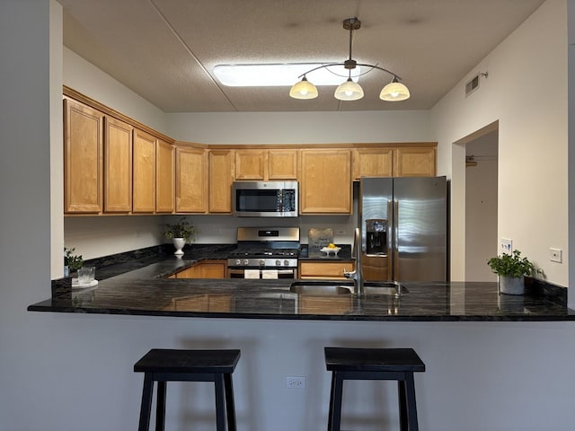 200 N Addison Ave Unit 505, Elmhurst, IL 60126 - kitchen with stainless steel appliances, a peninsula, dark stone counters, hanging light fixtures, and a kitchen bar
