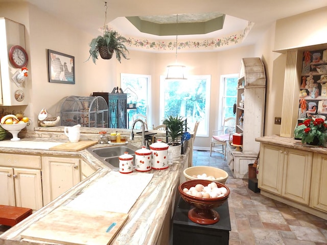 2S720 Nelson Lake Rd, Batavia, IL 60510 - kitchen featuring light countertops, cream cabinets, light stone finish floors, a tray ceiling, and hanging light fixtures