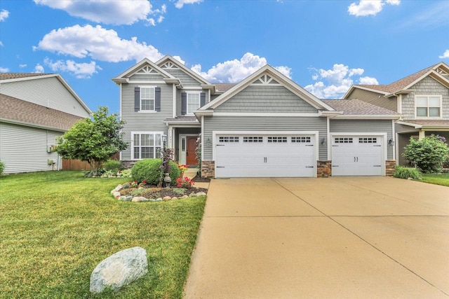 407 Banbury Ln, Savoy, IL 61874 - craftsman-style house featuring a garage, driveway, stone siding, and a front lawn