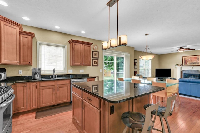 407 Banbury Ln, Savoy, IL 61874 - kitchen with appliances with stainless steel finishes, a kitchen breakfast bar, light wood-type flooring, open floor plan, and a ceiling fan