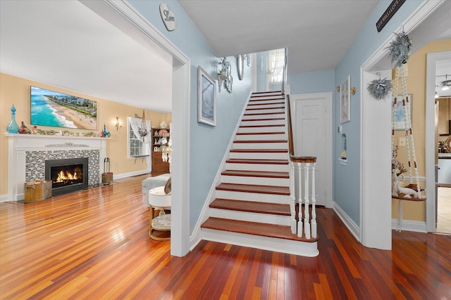 233 S Elmwood Dr, Aurora, IL 60506 - staircase with wood finished floors, baseboards, and a tiled fireplace