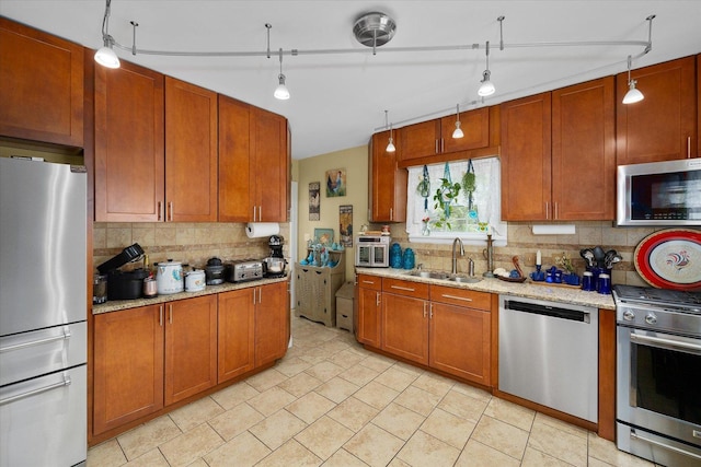 233 S Elmwood Dr, Aurora, IL 60506 - kitchen featuring stainless steel appliances, a sink, backsplash, light stone counters, and brown cabinets