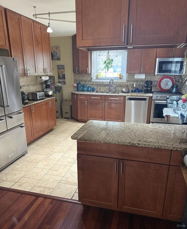 233 S Elmwood Dr, Aurora, IL 60506 - kitchen featuring stainless steel appliances, a sink, tasteful backsplash, light stone counters, and light wood-style floors
