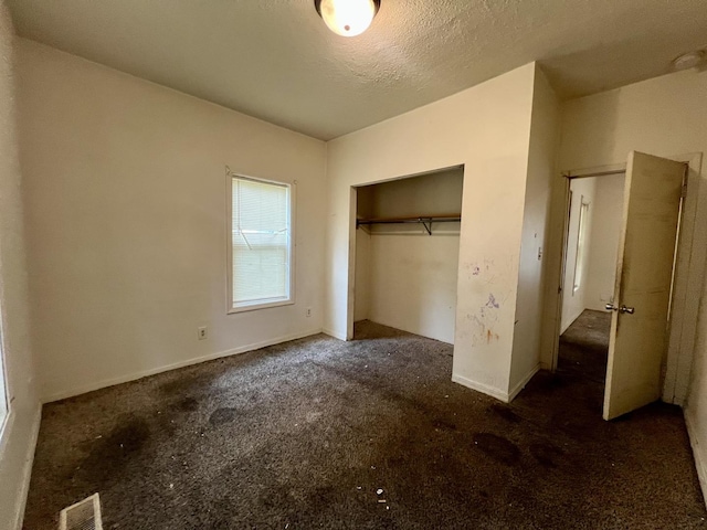 1205 W Beech St, Urbana, IL 61801 - unfurnished bedroom featuring carpet floors, a closet, and a textured ceiling