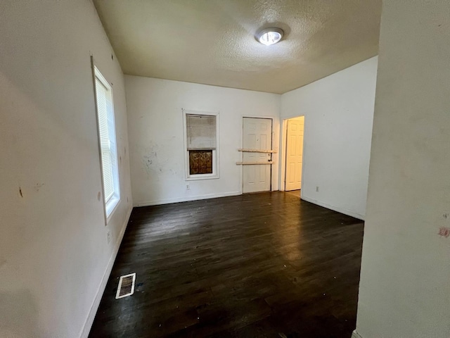 1205 W Beech St, Urbana, IL 61801 - unfurnished room with dark wood-style flooring, healthy amount of natural light, and a textured ceiling