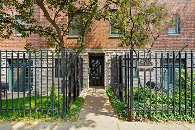 2500 N Seminary Ave Unit 4W, Chicago, IL 60614 - view of front of property featuring brick siding, a fenced front yard, a gate, and stone siding