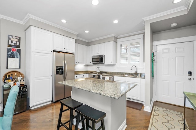 2500 N Seminary Ave Unit 4W, Chicago, IL 60614 - kitchen with stainless steel appliances, light stone counters, a kitchen breakfast bar, white cabinetry, and dark wood-type flooring