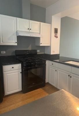 5387 Elizabeth Pl Unit 1302, Rolling Meadows, IL 60008 - kitchen featuring black gas range oven, under cabinet range hood, white cabinets, wood finished floors, and dark countertops