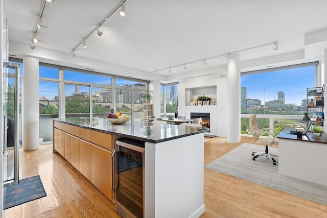 1035 W Huron St Unit 402, Chicago, IL 60642 - kitchen with wine cooler, track lighting, a view of city, a kitchen island, and light wood-type flooring