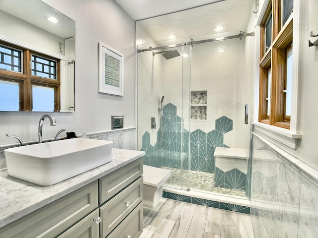 249 Jervey Ln, Bartlett, IL 60103 - bathroom with vanity, a shower stall, wainscoting, recessed lighting, and tile walls