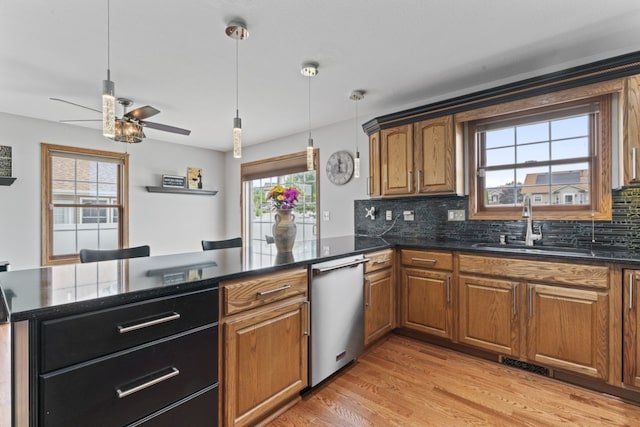 925 Magnolia Dr, Bourbonnais, IL 60914 - kitchen featuring stainless steel dishwasher, ceiling fan, brown cabinets, light wood-style flooring, and tasteful backsplash